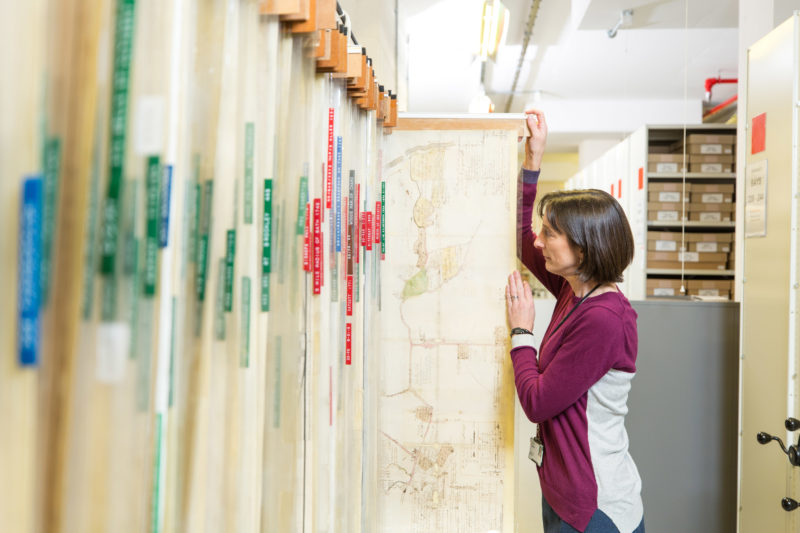 Archivist looking at map