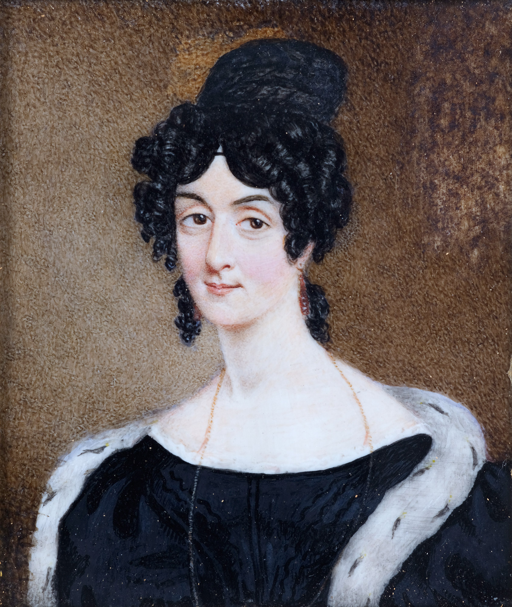 Portrait of a women wearing a black dress, fur-lined shawl, with dark curly hair.