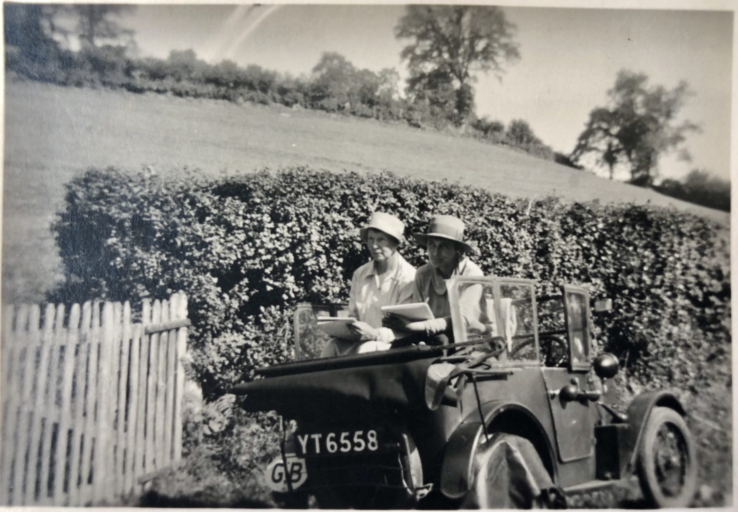 Black and white photograph of Doris and friend sketching from the car