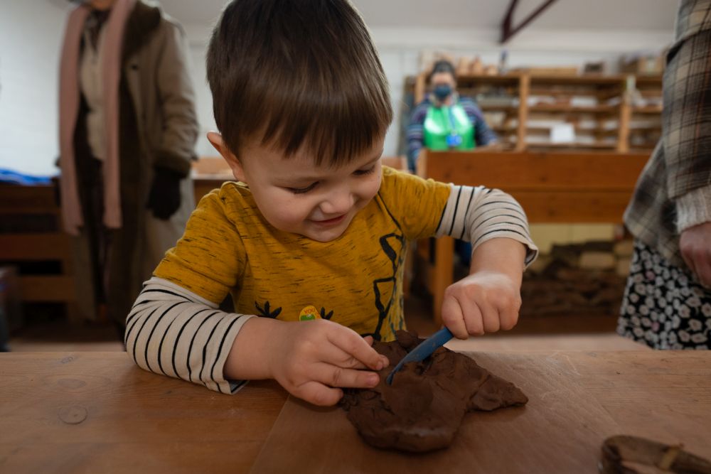 Child with hands in clay