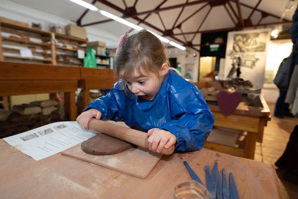 Child rolling clay
