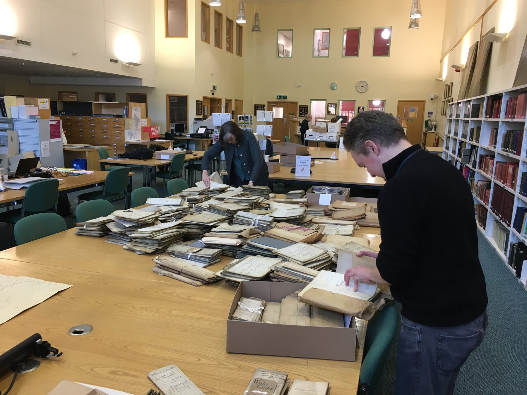 Two people surrounded by boxes and papers