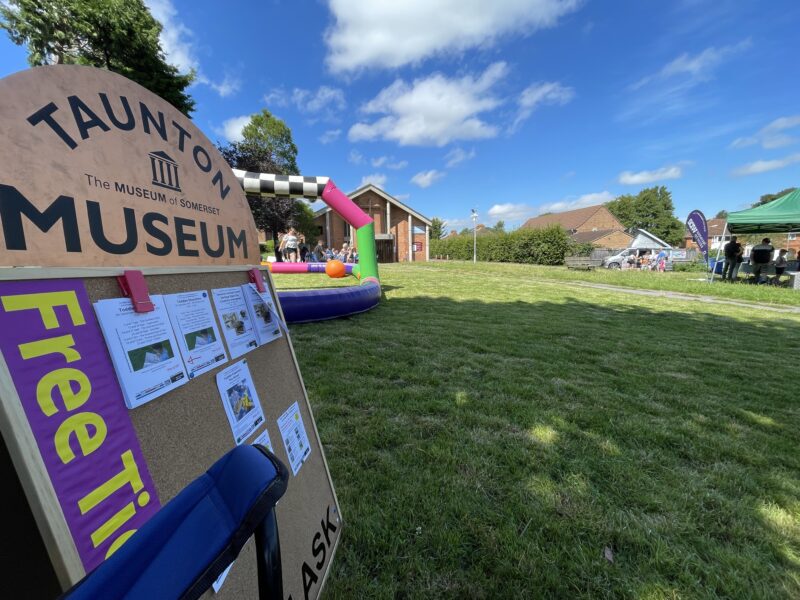 Sign with a bouncy castle in the background.