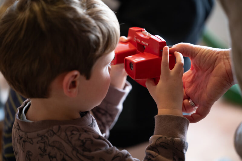 Child looking into viewmaster, facing away from camera.