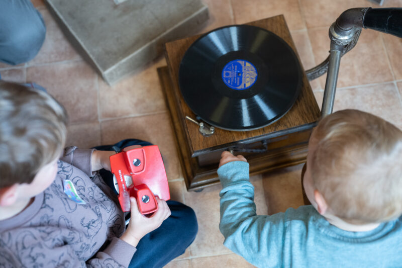 Children sat playing near a gramophone.