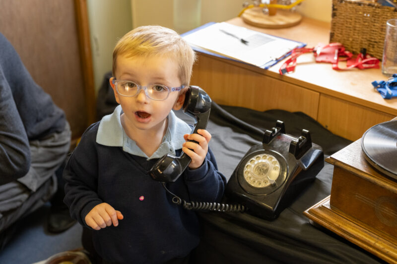 A child using a vintage telephone.
