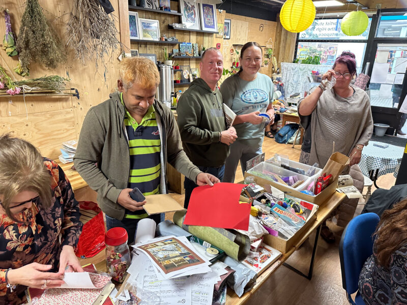 People gathered around table of objects.