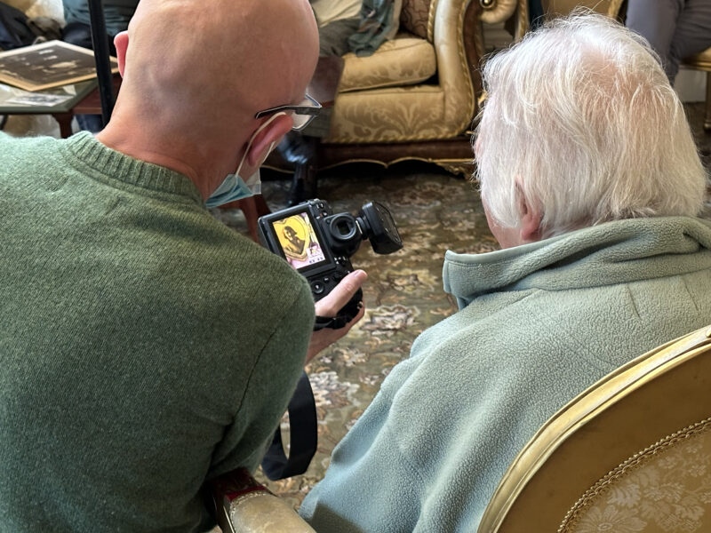 Two people photographed from behind looking at a camera.