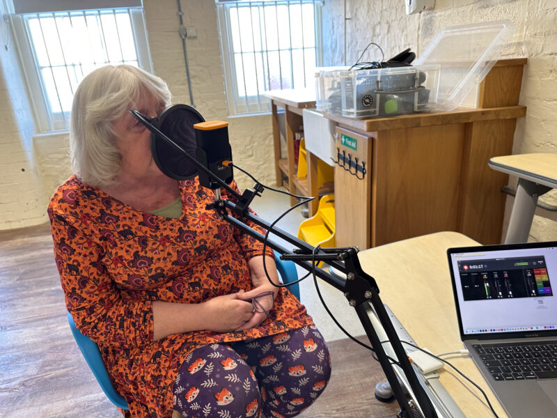 Woman sat in front of a microphone.