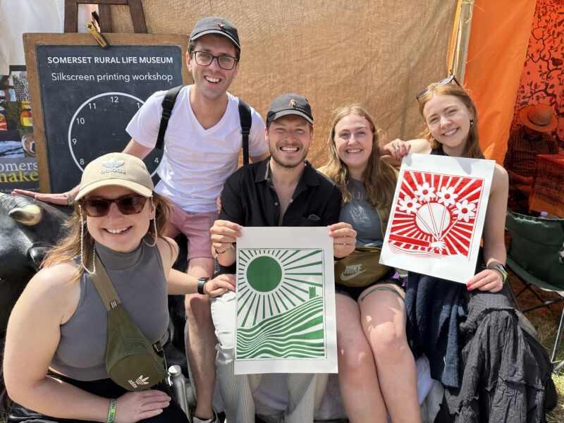 A group of people holding up their artworks towards the camera.