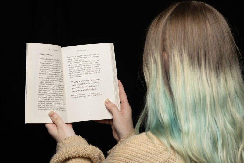 Person holding book open.
