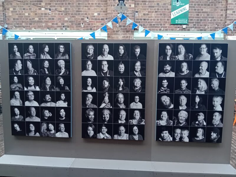 Three large canvases full of black and white portraits.