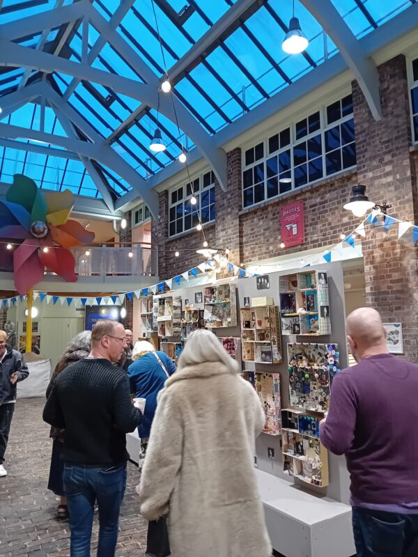 People stood in a courtyard looking at an exhibition.