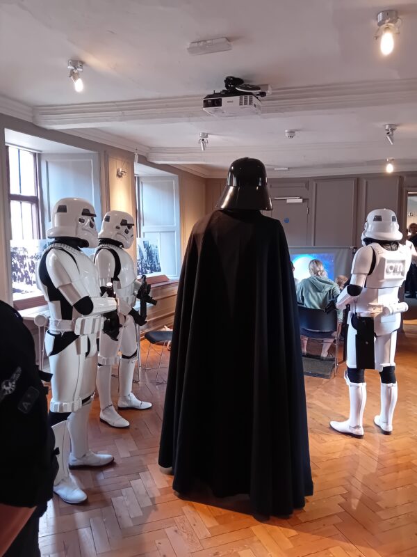 People dressed as Darth Vader and Stormtroopers stood in a circle.