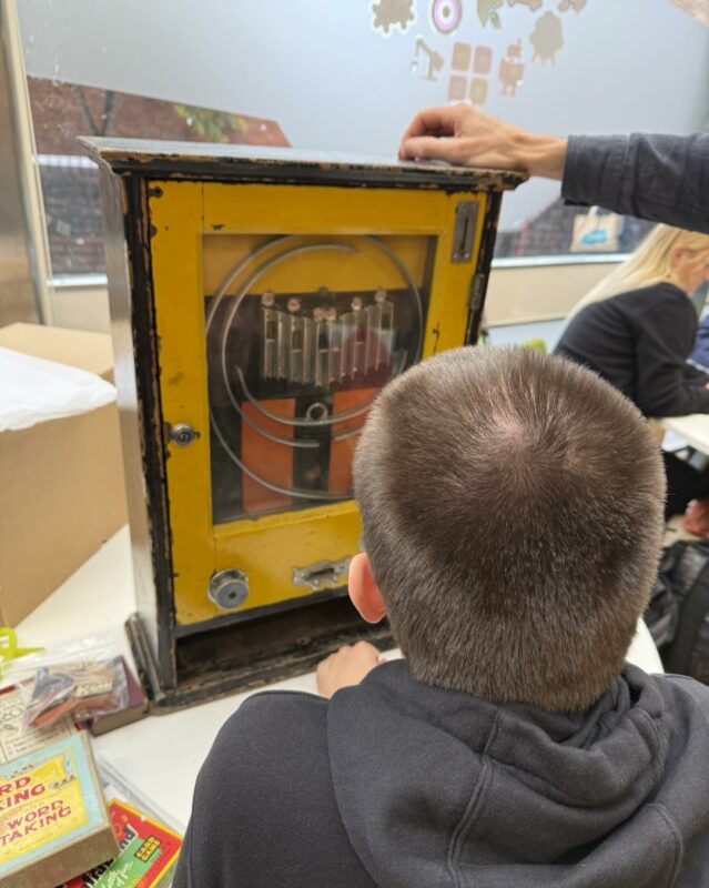 Person facing away from the camera playing a vintage game.