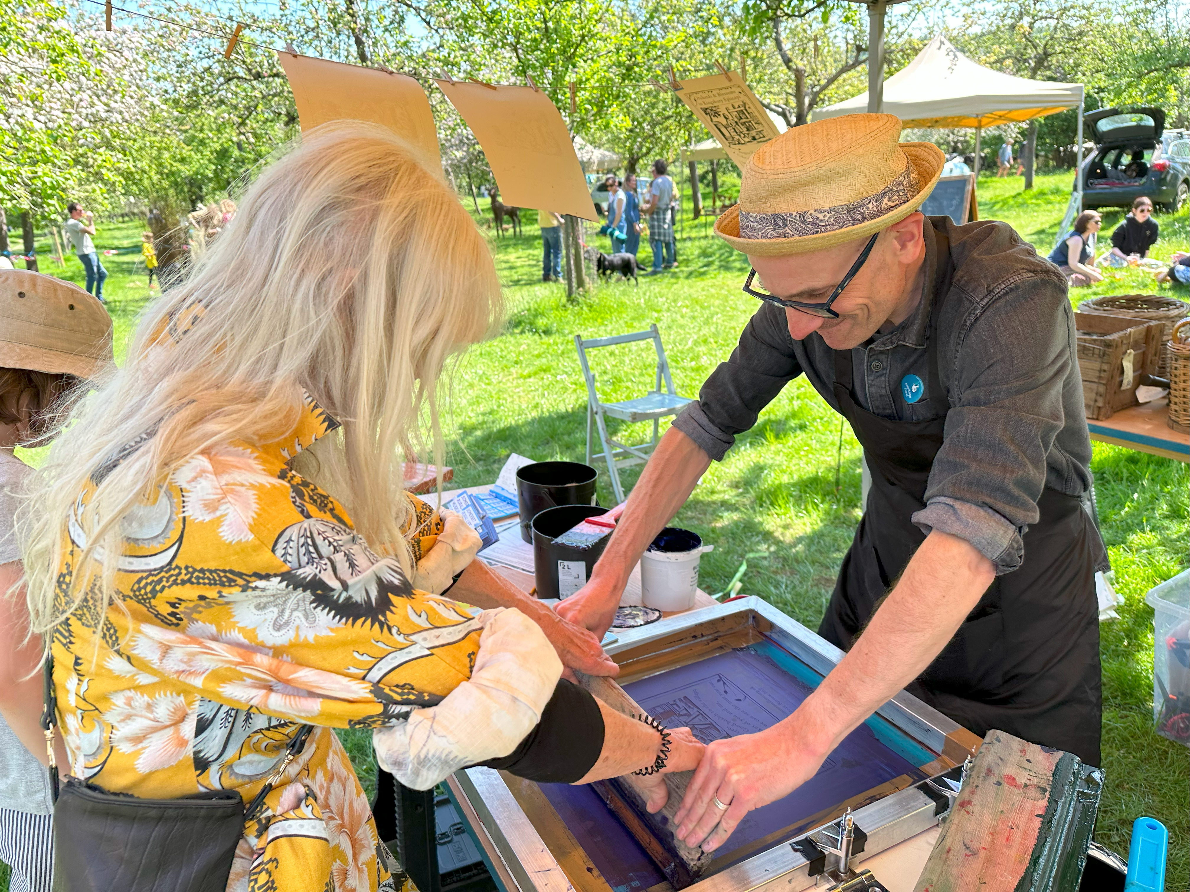 Man helping a participant do a screen print.