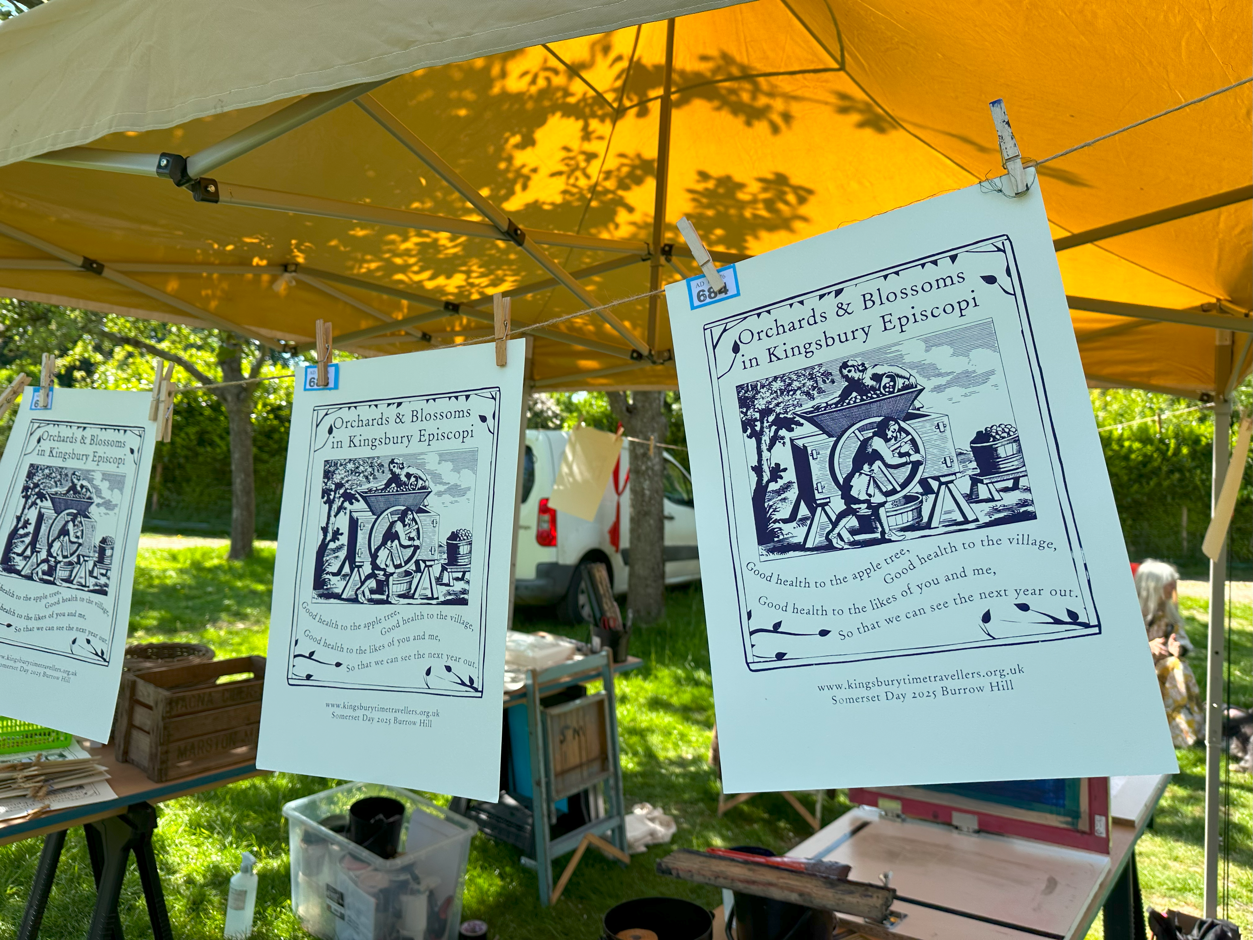 Artworks hanging up on a line, with equipment in the background.