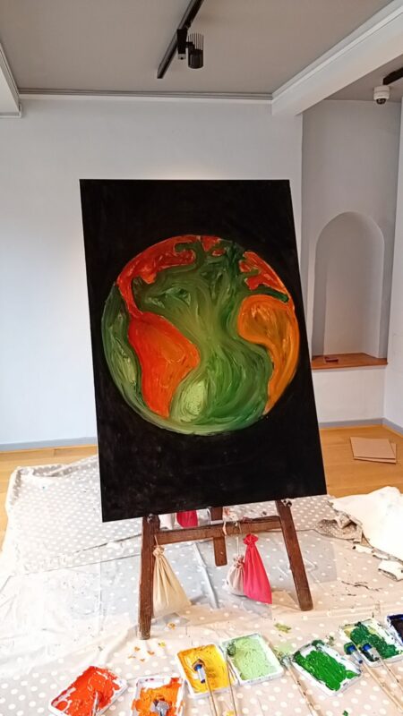 A large painting of earth on an easel.