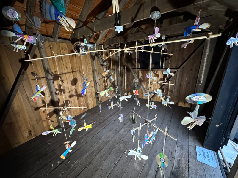 Angel figures suspended in wooden room.