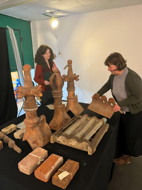 Two people setting up display of museum objects.