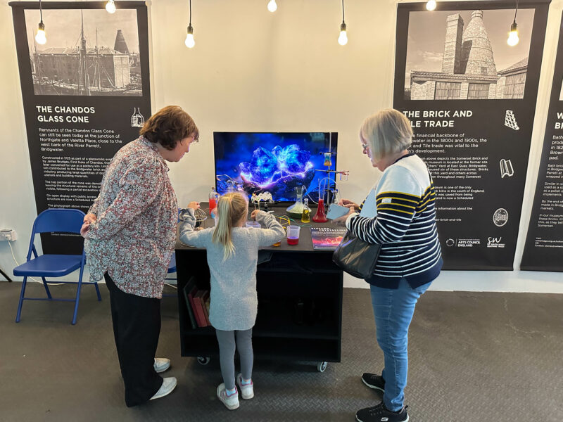 Three people engaging with the experiment installation.