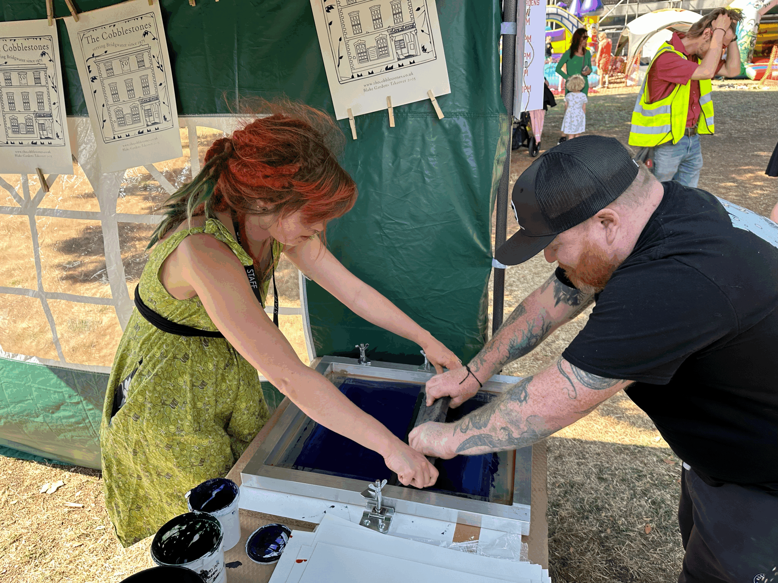 Two people doing a screenprint together.