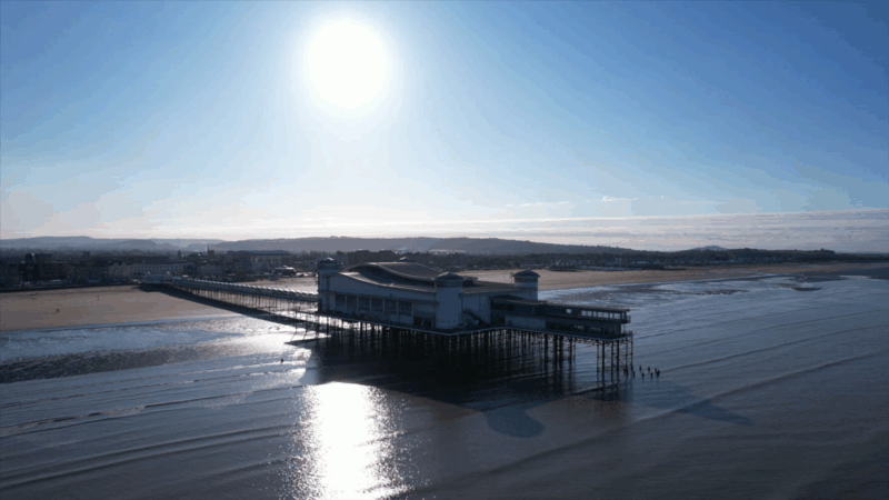 A picture of Weston-super-Mare pier, beach and sea front from over the sea.
