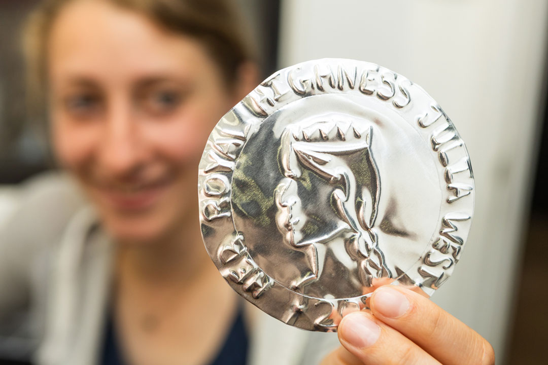 A participant holding up an embossed foil coin.