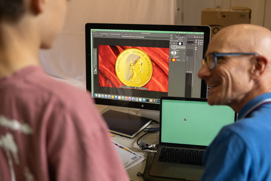 A team member showing a photograph of a coin to a young boy.