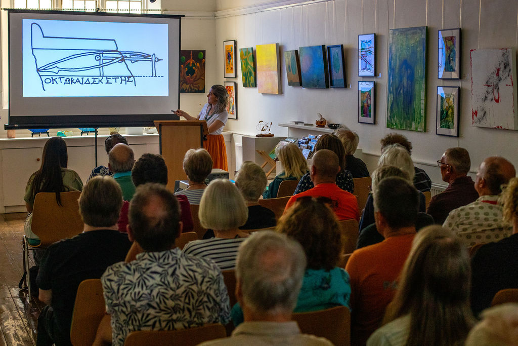 A gathering of people watching a talk about the roman ring.