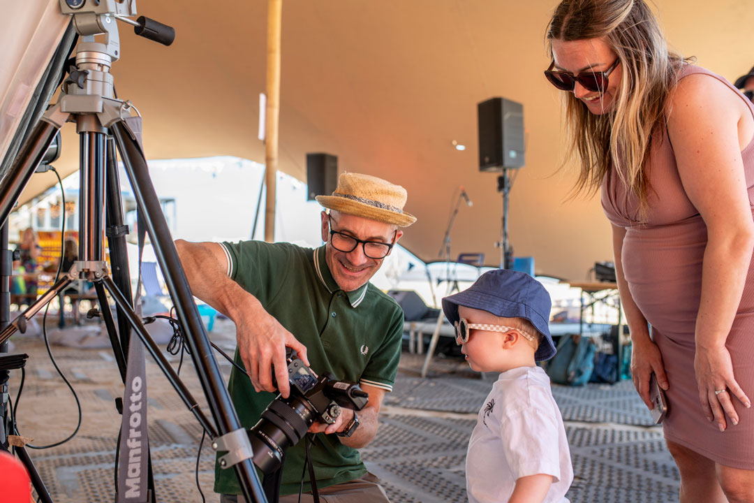 A mother and her young child being shown their self-portrait by the photographer.